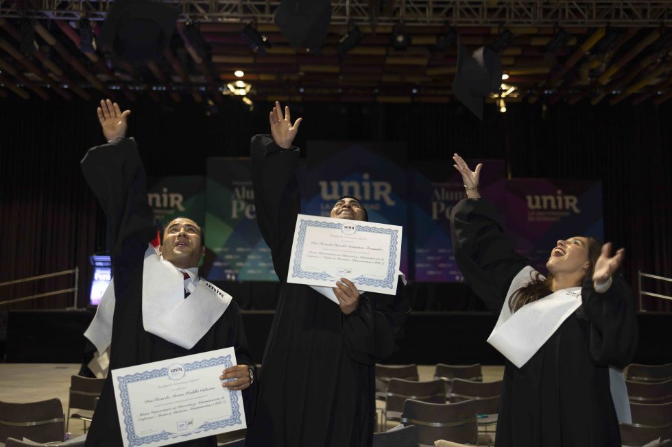 Los egresados celebran su éxito alzando sus birretes: un gesto de alegría y gratitud.