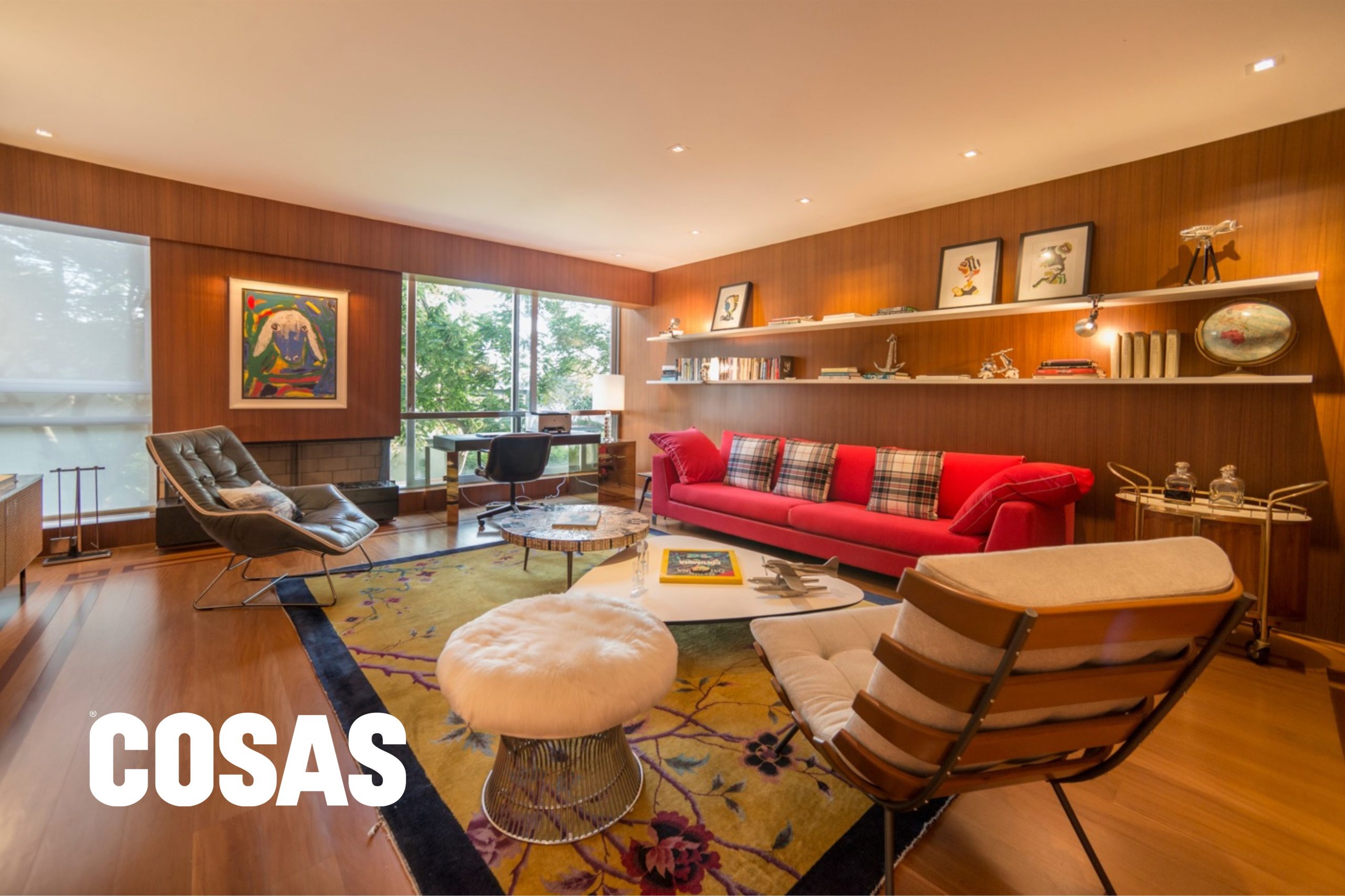 Kathy trabajó uno de los ambientes de la casa enchapado en madera para brindar un toque cálido. En esta área conviven sillones vintage, una banca Platner y un escritorio original de Gio Ponti.