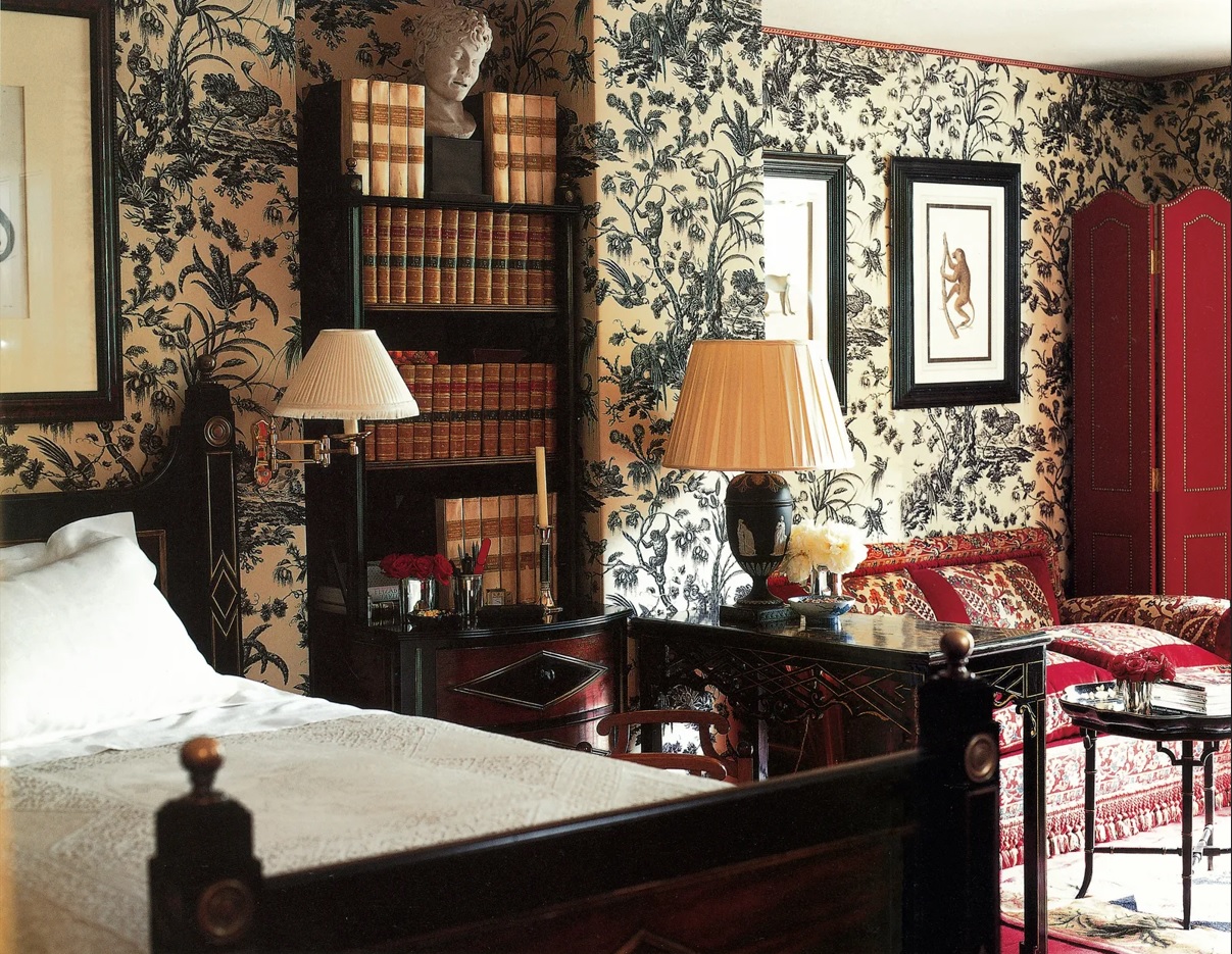 En la habitación de invitados, un Toile de Jouy enmarca una cama rusa del siglo XIX, acompañada por estanterías a juego y grabados de monos.