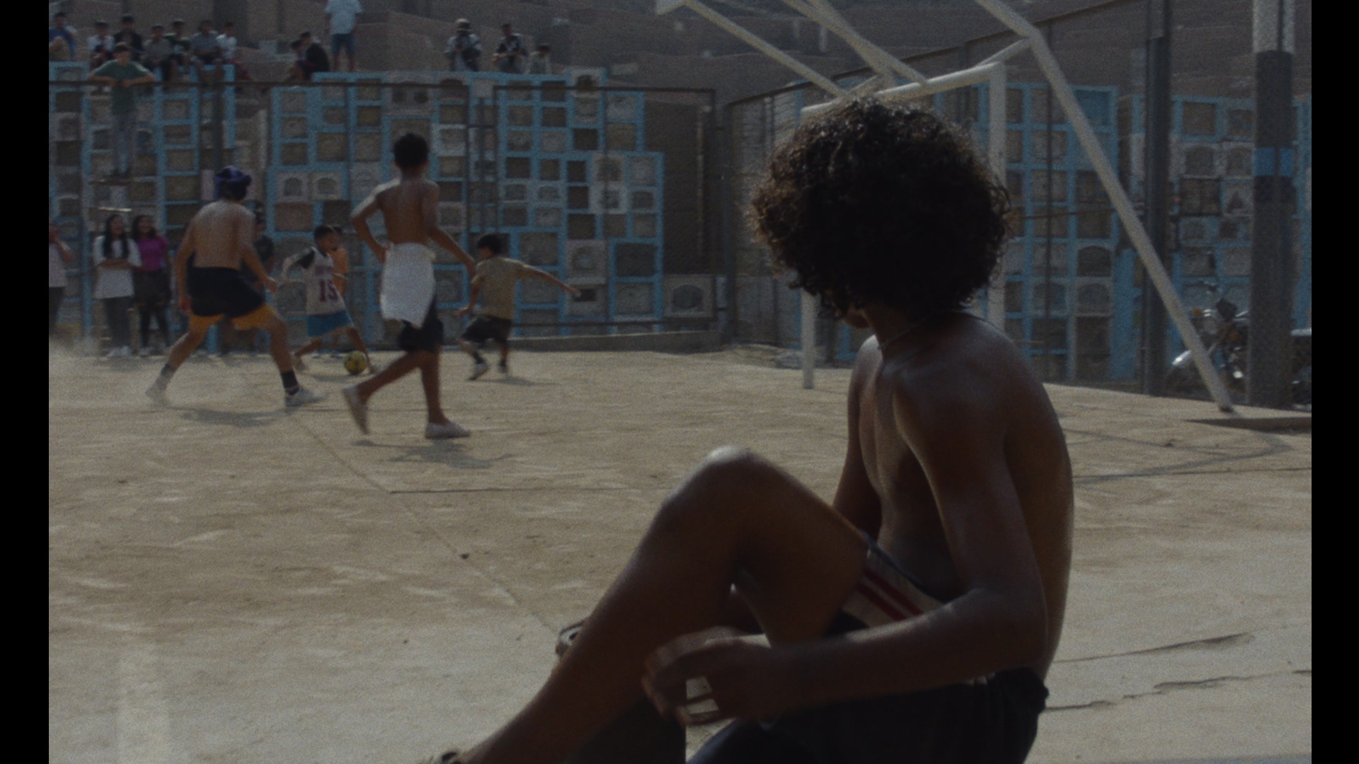 El cementerio como cancha. Un espacio donde los muertos observan y los vivos juegan, sin fronteras claras.