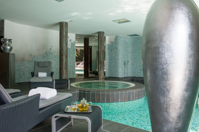 Sauna, hammam y zonas de descanso completan la propuesta de bienestar, en un guiño a los sanatorios alpinos que marcaron la historia arquitectónica de la región.