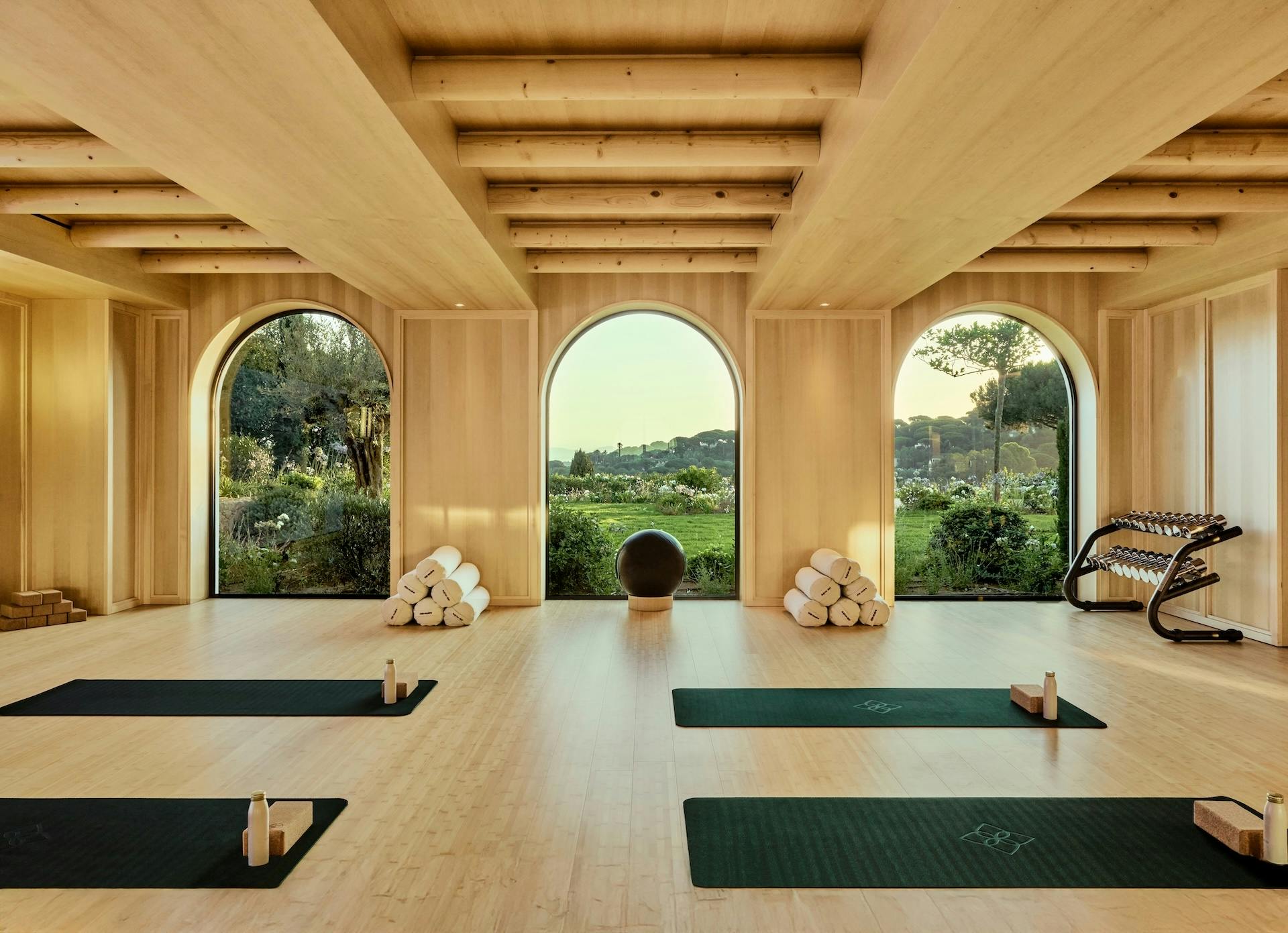 Sala de fitness bañada por luz natural, donde el bienestar se vive con calma y vistas abiertas a los jardines del hotel.