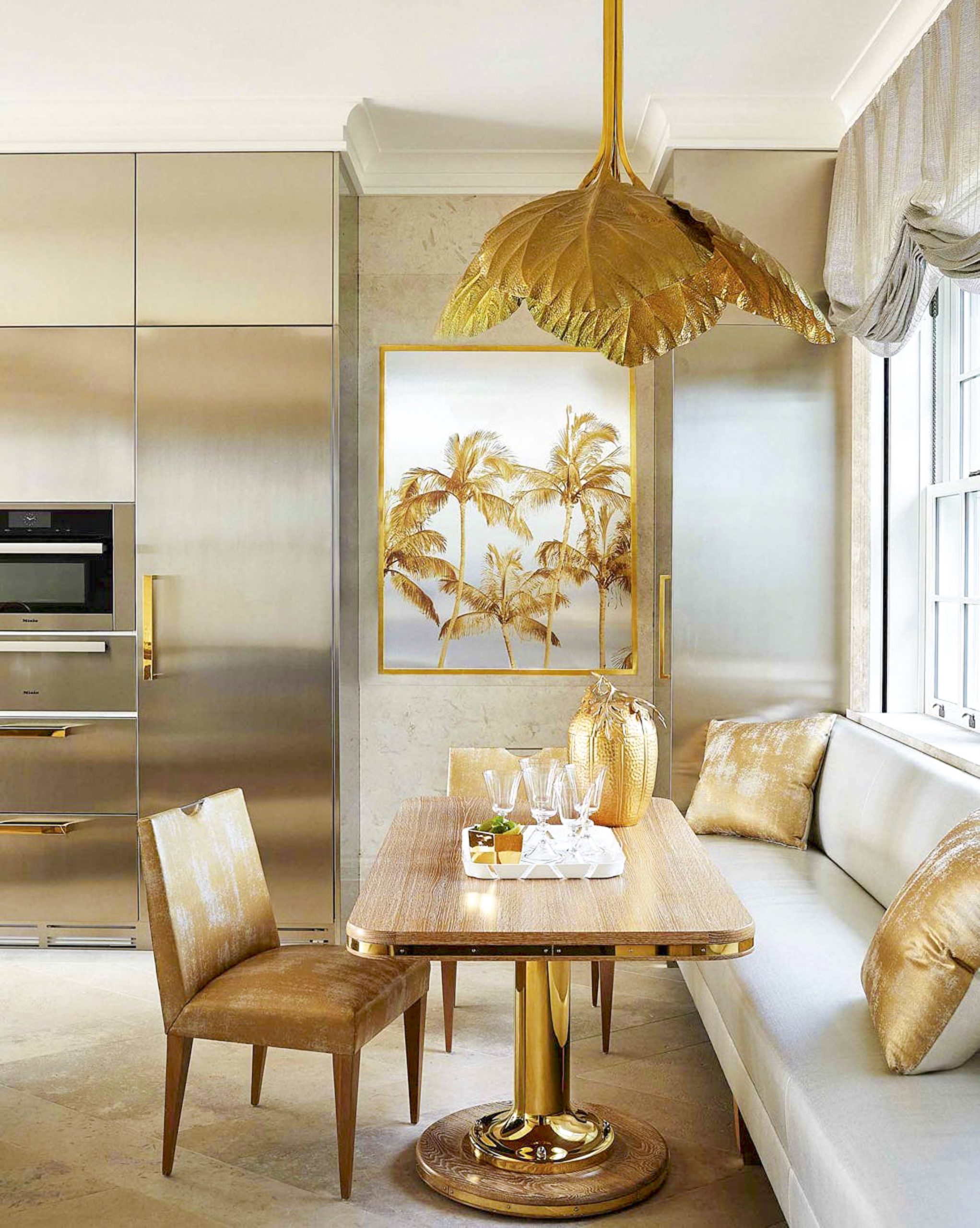 Una lámpara de araña vintage de hojas de latón de Tommaso Barbi deja una impresión audaz en esta cocina diseñada por Alex Papachristidis.