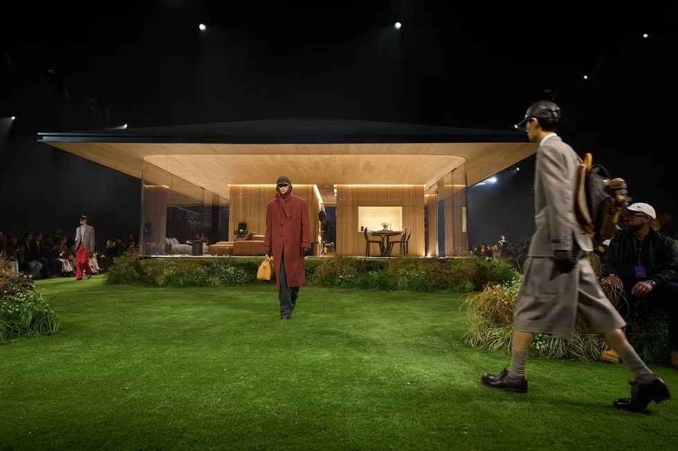 Modelos de la colección masculina Otoño–Invierno 2026 de Louis Vuitton desfilan en los exteriores de DROPHAUS, la casa de cristal concebida por Pharrell Williams en París.