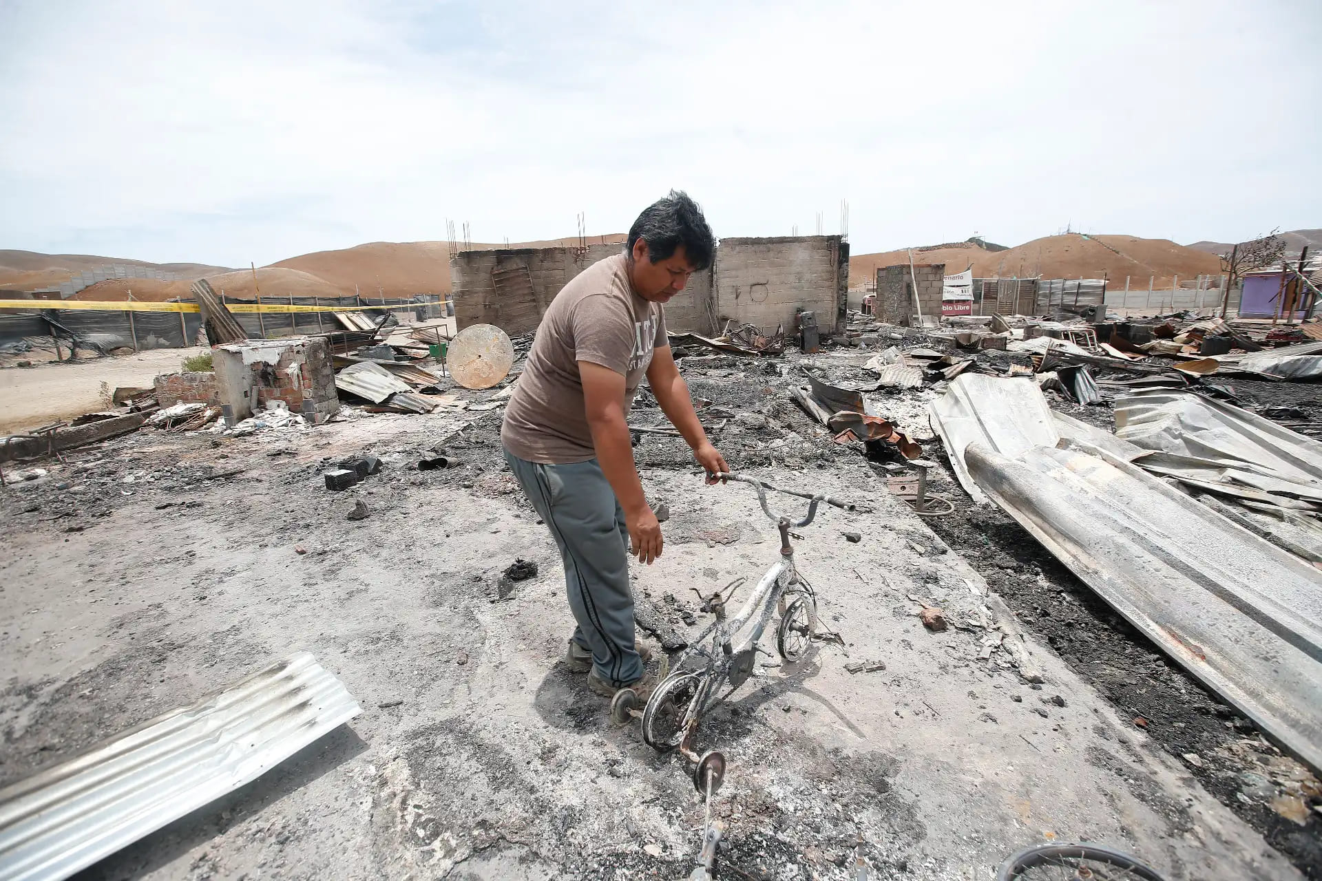Entre cenizas y restos calcinados, un vecino revisa lo poco que quedó tras el ataque ocurrido durante la madrugada en Pucusana.