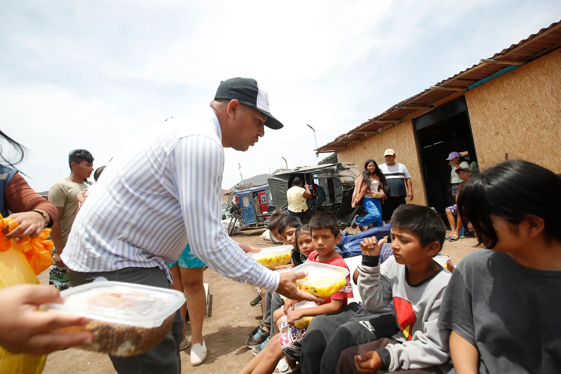 Niños damnificados reciben alimentos luego del incendio que dejó a decenas de familias sin vivienda en la Asociación Amor al Prójimo.