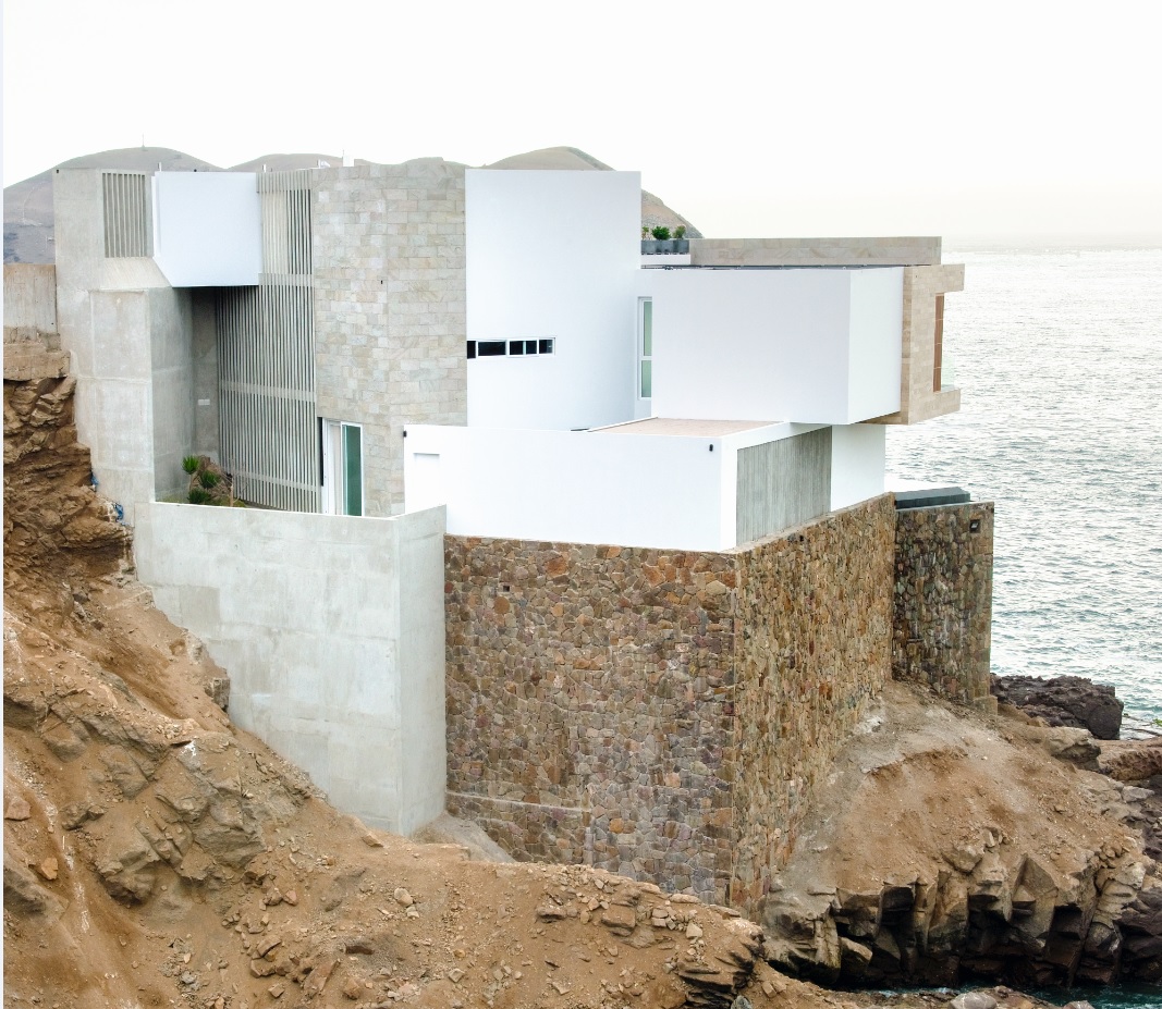 Los voladizos y quiebres del volumen no son un gesto formal: permiten encuadrar vistas específicas del mar y aprovechar la condición angular del peñasco.