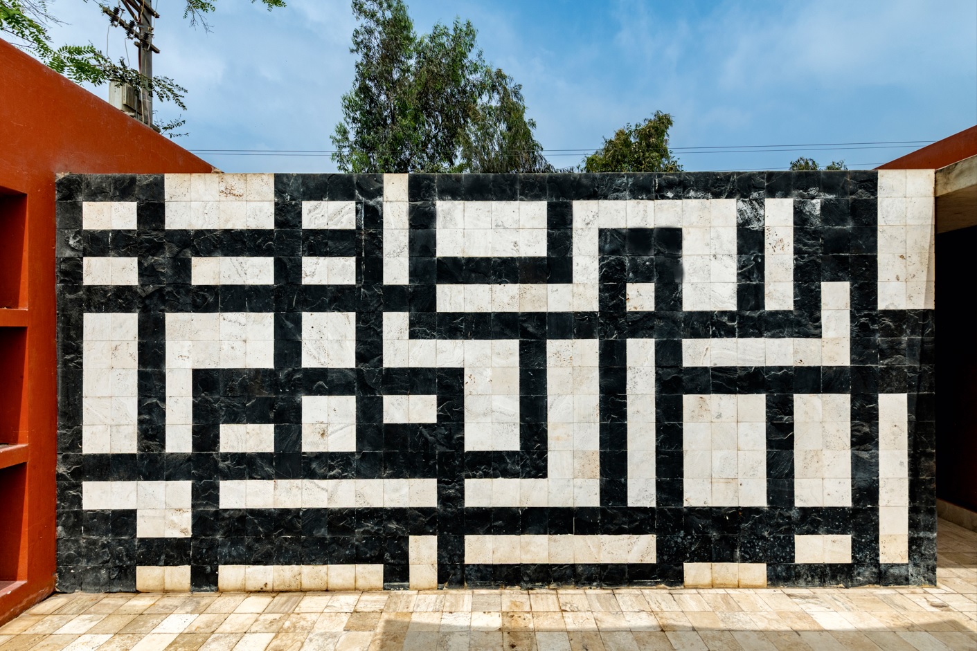 El muro geométrico en blanco y negro marca el ritmo del recorrido exterior y reafirma el carácter introspectivo de la casa, volcada hacia su propio universo.