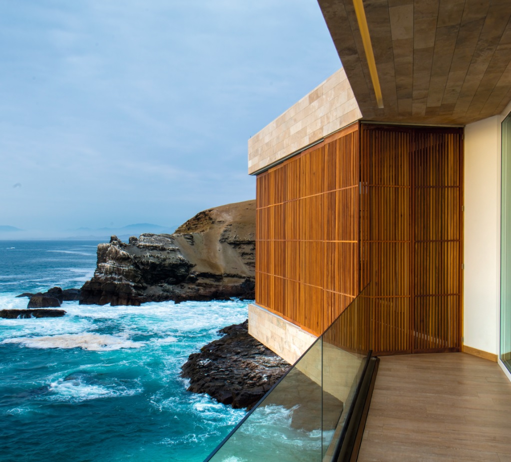 El balcón corrido se proyecta sobre el vacío y refuerza la sensación de estar suspendido sobre el Pacífico, con vistas directas a los espigones.