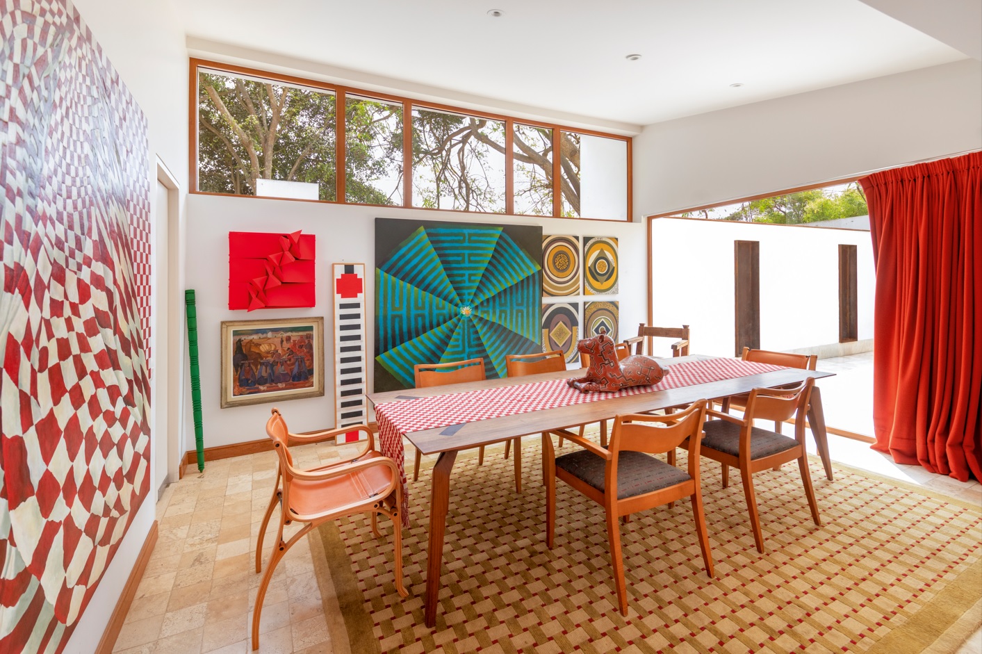 El comedor se abre hacia el patio central, reafirmando el corazón introspectivo de la casa. Las obras dialogan con la arquitectura moderna, tal como lo imaginó Sert: arte y vida cotidiana compartiendo un mismo espacio.