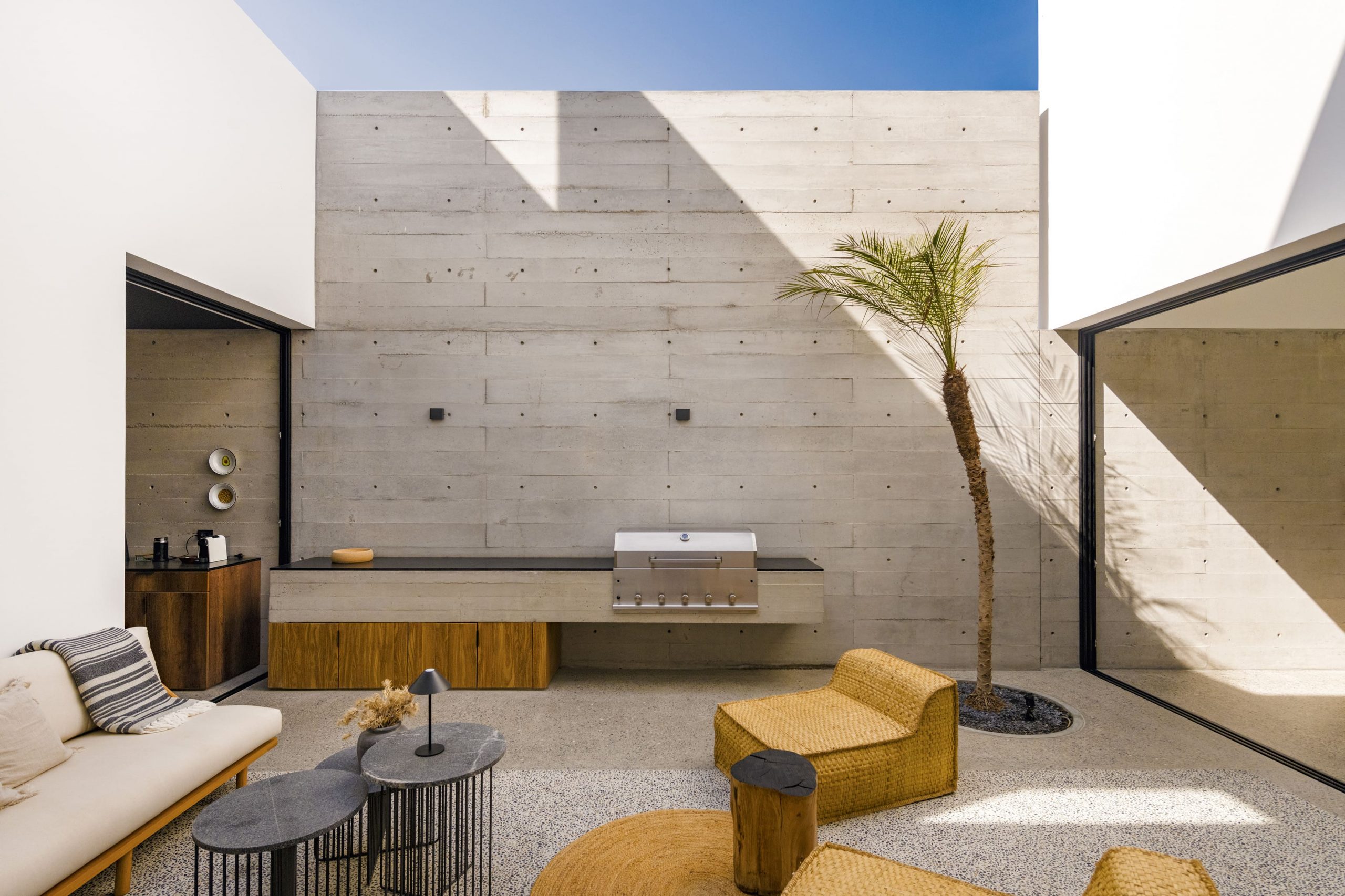 El patio como extensión del interior, un espacio de sombra y encuentro donde el desierto se incorpora a la casa.