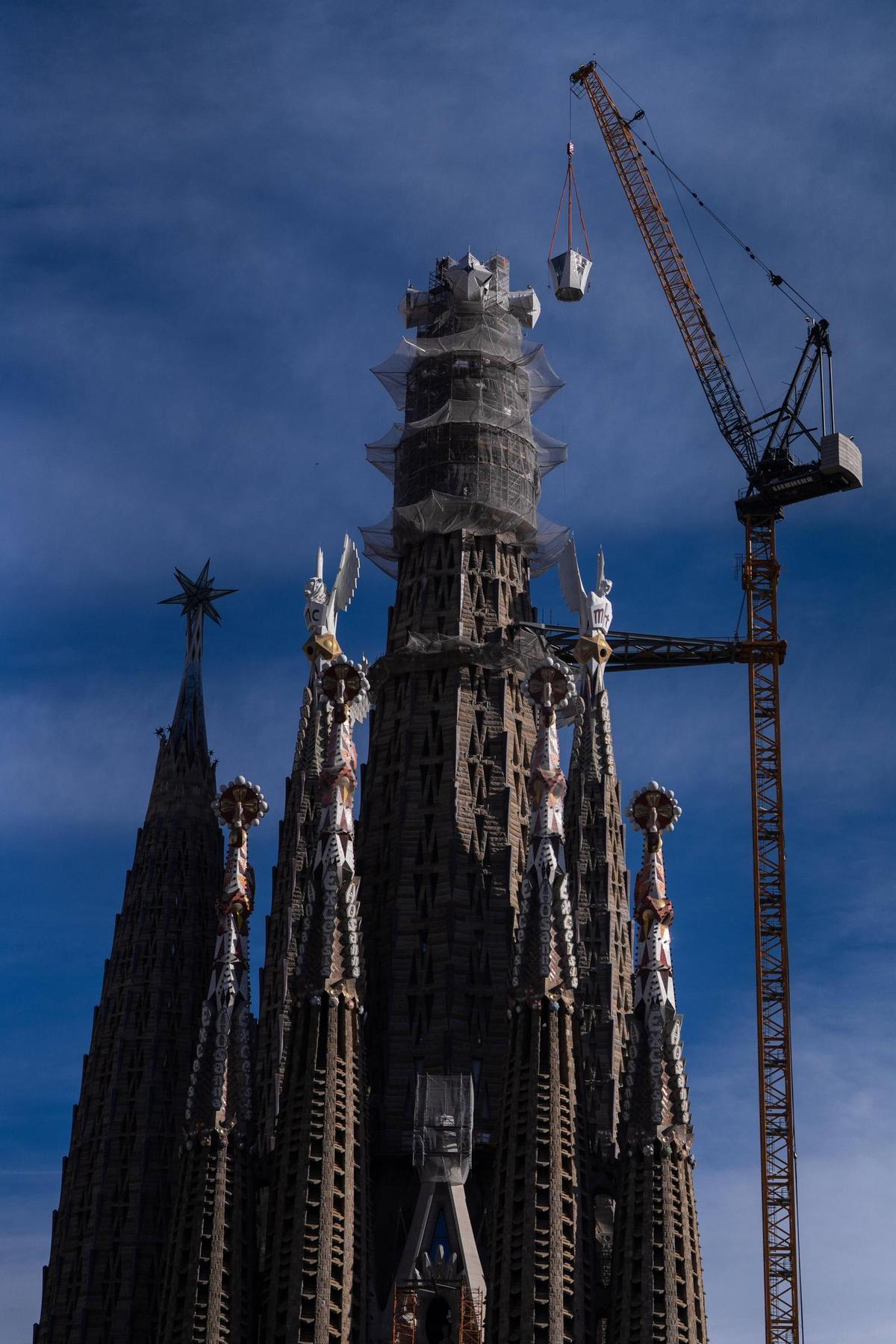 Con apoyo de una grúa de gran escala, el brazo superior de la cruz —de 17 metros de altura— es colocado en la cima de la torre más alta del templo diseñado por Antoni Gaudí.