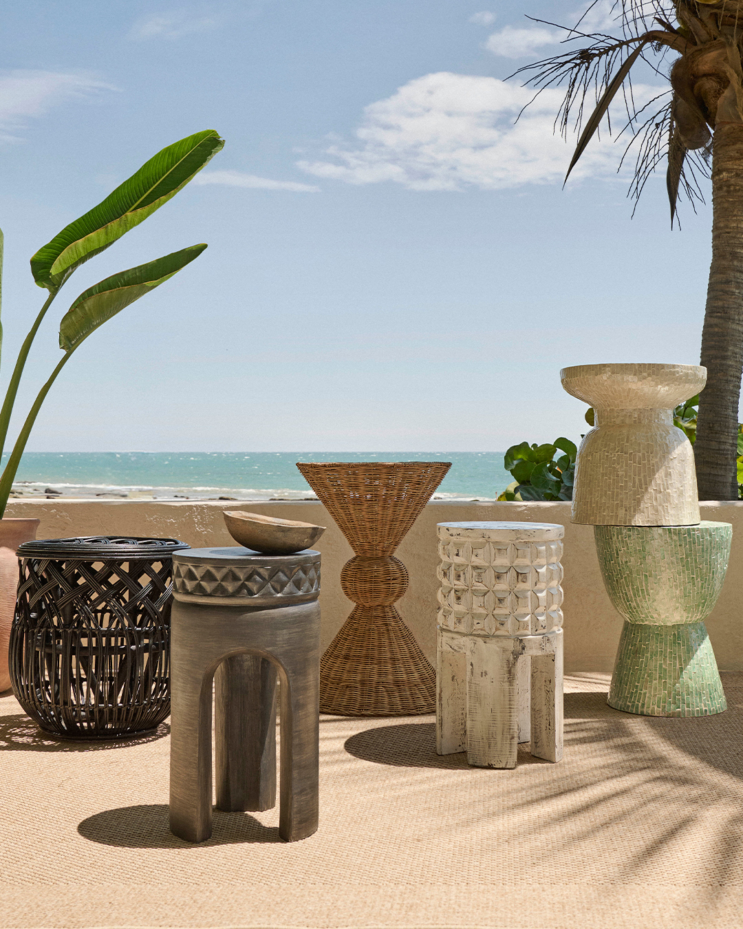 Mesas auxiliares y objetos decorativos que juegan con la textura y la forma, pensados para interiores relajados y luminosos.