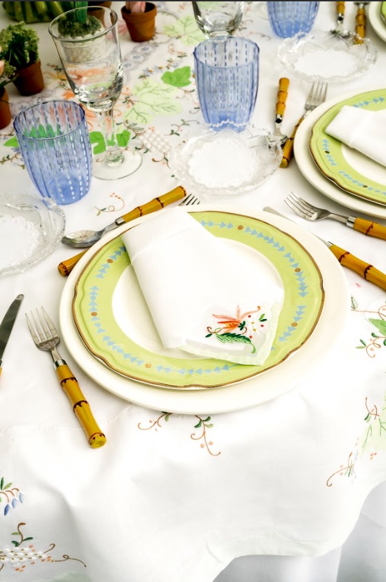 Vajilla de tonos suaves, cubiertos con mango de bambú y cristalería azul componen una mesa fresca y natural, pensada para disfrutar el almuerzo de verano al aire libre.