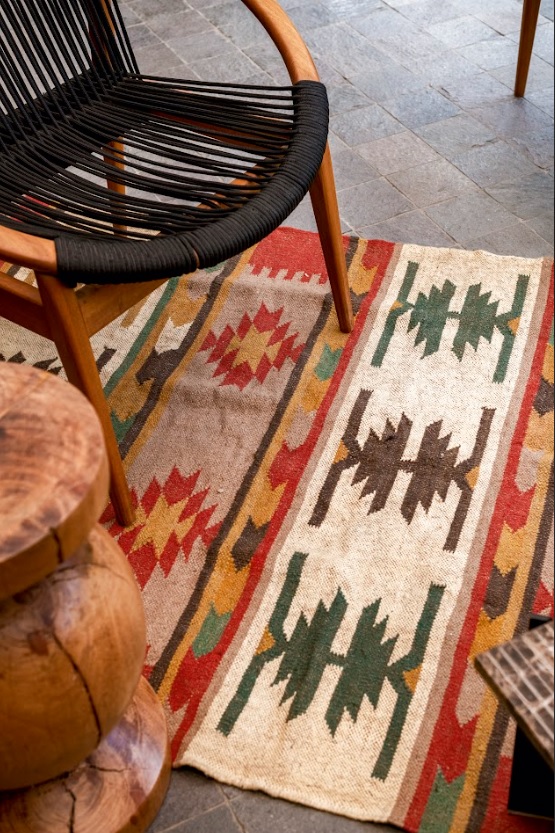 Un textil de inspiración andina introduce color y textura en la terraza, sumando calidez al mobiliario de madera y fibras naturales.