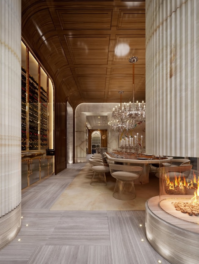 Comedor principal de la residencia, con lámparas de cristal, paneles de madera curvada y una cava de vinos integrada en la arquitectura interior.